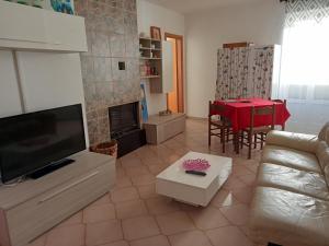 a living room with a couch and a tv and a table at bed and breakfast- Ai piedi del parco in San Donato Val di Comino