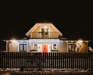 ein Haus mit Balkon darüber in der Nacht in der Unterkunft PUSZCZYKOWO siedlisko&spa in Białowieża