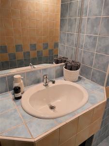 lavabo blanco en un baño con azulejos azules en Prague apartment, en Praga