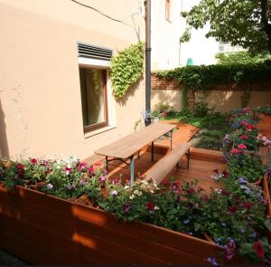 een houten bank in een tuin met bloemen bij Prague apartment in Praag