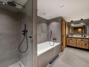 W łazience znajduje się wanna i prysznic. w obiekcie Chalet Neuf avec Piscine, Sauna et Proche des Pistes à Courchevel Village - FR-1-562-47 w Courchevel +8 zdjęć