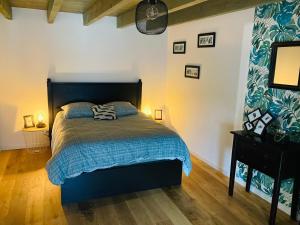Schlafzimmer mit einem Bett mit blauer Decke in der Unterkunft Magnifique Maison Familiale in Quistinic