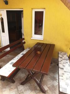 uma mesa de madeira sentada em frente a uma parede amarela em Vilmos Pince Fogadó em Hévíz