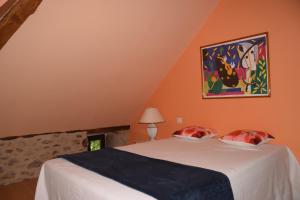 1 dormitorio con 1 cama y una pintura en la pared en Le four à pain en Najac