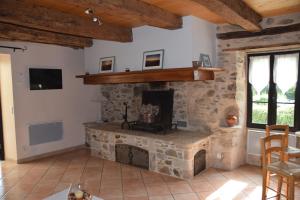 a living room with a stone fireplace in a house at Le four à pain in Najac