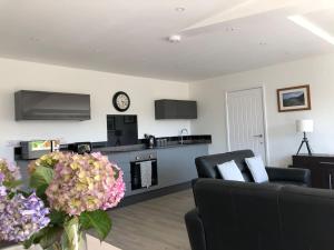 ein Wohnzimmer mit einer Couch und einem Tisch mit Blumen in der Unterkunft Meadow Cottage. Pretty modern cottage close to Woolacombe and Lee in Ilfracombe