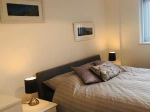 1 dormitorio con 1 cama con 2 lámparas en Meadow Cottage. Pretty modern cottage close to Woolacombe and Lee, en Ilfracombe