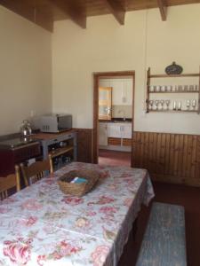 a room with a table and a kitchen with a counter at Bo-Plaas Farmhouse in Bredasdorp