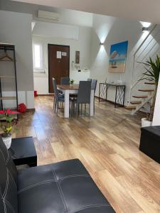 a living room with a table and chairs and a staircase at Maison Damas in Barletta