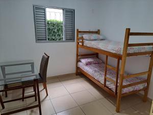 a room with two bunk beds and a table and a window at CASA LUGAR TOP - prefeitura, UNITAU, hospital e Av do Povo in Taubaté