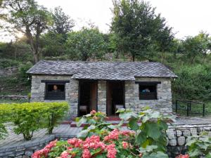 una pequeña casa de piedra con dos personas en la ventana en River Edge Resort Nepal en Benighāt