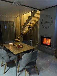 a dining room with a table and a fireplace at Prostir 65 in Slavske