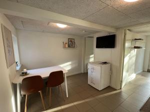 una cucina con tavolo, sedie e un piccolo frigorifero di På landet a Grindsted
