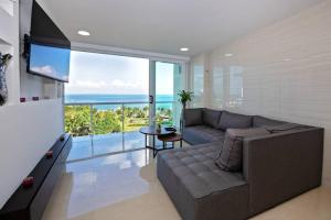 uma sala de estar com um sofá e vista para o oceano em Amara, depa con vista al mar em Cancún