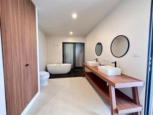 a bathroom with two sinks and a bath tub at Rajapruek Samui Resort - SHA Plus in Lipa Noi
