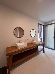 a bathroom with two sinks and two mirrors at Rajapruek Samui Resort - SHA Plus in Lipa Noi