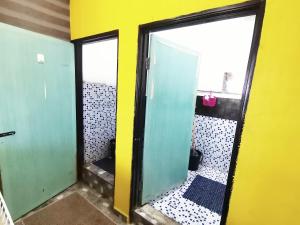 a bathroom with two green doors and a yellow wall at Bluewave Sea Out Seaview Homestay in Kuah