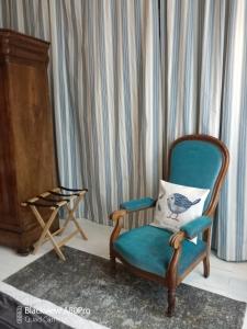 una silla con una almohada junto a un piano en Chambre Bounty cuisine privée, salle d'eau, terrasse, garage, en Olliergues