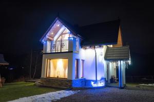 dom oświetlony w nocy światłami świątecznymi w obiekcie Modrzewiowa Ostoja II w Kluszkowcach