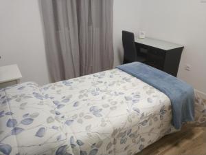 a bed in a room with a desk and a bedskirtspectspectspectspects at Índigo in Santa Cruz de la Palma