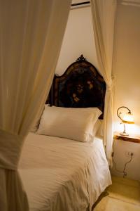 a bedroom with a white bed with a canopy at Masseria Filippo de Raho - Agri Bio Relais in Villa Convento