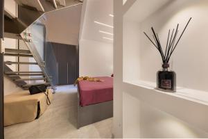 a room with a bed and a vase with sticks at CASA LUCKY CENTRAL APARTMENT in Piano di Sorrento
