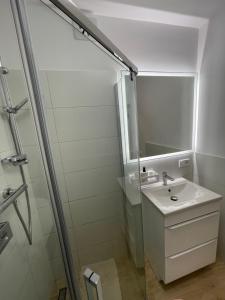 une salle de bain blanche avec lavabo et douche dans l'établissement Hilltom Dunes, à Rowy 19 autres photos