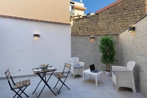 a patio with chairs and a table with a laptop on it at CASA LUCKY CENTRAL APARTMENT in Piano di Sorrento