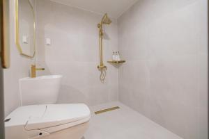 Baño blanco con aseo y lavamanos en Denbasta Hotel Heritage en Gyeongju