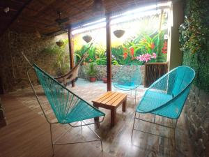 2 sillas, una mesa y una hamaca en el patio en Hotel Malibu, en San Juan Nepomuceno