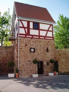 un edificio in mattoni con tetto rosso e bianco di Außergewöhnliche Übernachtung im Wehrturm a Bad Hersfeld