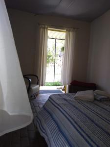 a bedroom with a bed and a window at Recanto Cheio de Cheiro in Guararema