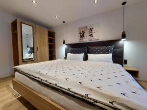 Schlafzimmer mit einem großen Bett mit einem schwarzen Kopfteil in der Unterkunft Appartement Hartl in Filzmoos
