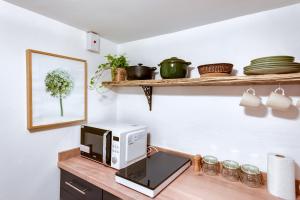 una cocina con microondas en una encimera de madera en The Summertown STUDIO 1BR & kitchenette en Oxford