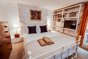 ein Schlafzimmer mit einem weißen Bett und einem TV in der Unterkunft The Summertown STUDIO 1BR & kitchenette in Oxford