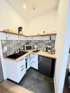 a small kitchen with a sink and a microwave at Studio confort #2, proche Gare et commodités in Maubeuge