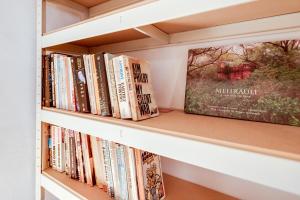 un estante con libros y un cartel en él en The Summertown STUDIO 1BR & kitchenette en Oxford