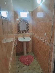 y baño con lavabo y espejo. en Afgo Hostel, en Ouarzazate