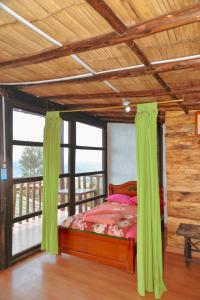 1 dormitorio con 1 cama con cortinas verdes en MIRADOR DE MARCURA, en Paipa