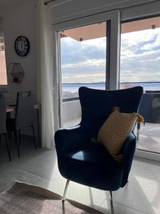 スベティ・フィリップ・イ・ヤコブにあるSea Bay View apartment - Appartement avec piscine et magnifique vue sur merの窓のある部屋(青い椅子付)