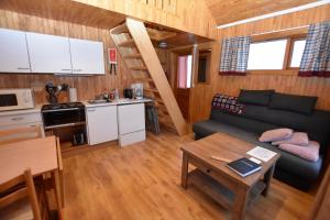 una pequeña sala de estar con sofá y mesa. en Sólbrekka Holiday Homes en Mjóifjörður