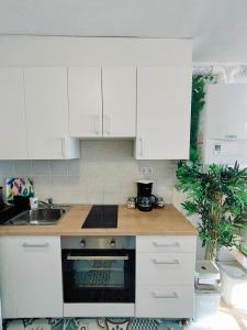 a kitchen with white cabinets and a sink at Studio Apartment TIM in Zagreb