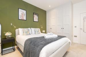 een slaapkamer met een bed en een groene muur bij Heliodoor Apartments St Albans City GREAT LOCATION Direct trains to London St Pancras 18 mins, Gatwick & Luton Airports in Saint Albans