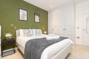 a bedroom with a bed and a green wall at Heliodoor Apartments St Albans City GREAT LOCATION Direct trains to London St Pancras 18 mins, Gatwick & Luton Airports in St. Albans