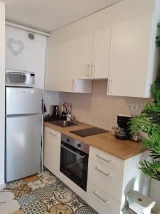 a kitchen with white cabinets and a white refrigerator at Studio Apartment TIM in Zagreb