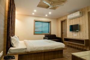 兰奇Hotel Sohrai Inn的一间卧室，配有一张床、一把椅子和一台电视机