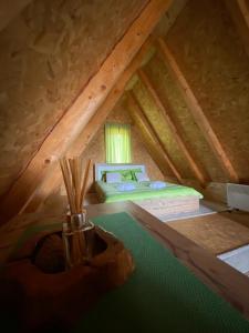 a attic bedroom with a bed in a attic at Vila Luka i Ana - Apartman Ana in Zaovine