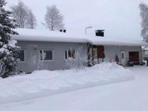 a house covered in snow in front of it at Talo-Villa- 3 mh+s - Kittilä - Levi upea keittiö in Kittilä