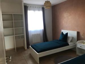 una camera da letto con un letto con lenzuola blu e una finestra di Résidence privée calme 15 min à pied du centre parking gratuit a Arles