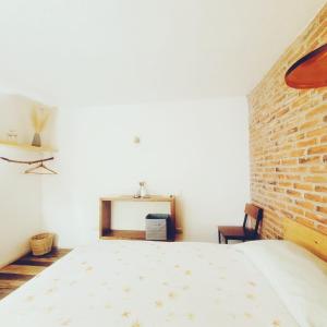 um quarto com uma cama e uma parede de tijolos em Hostal Hoja Santa em Cholula